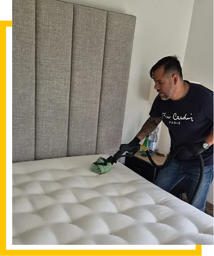 Technician steam cleaning a mattress